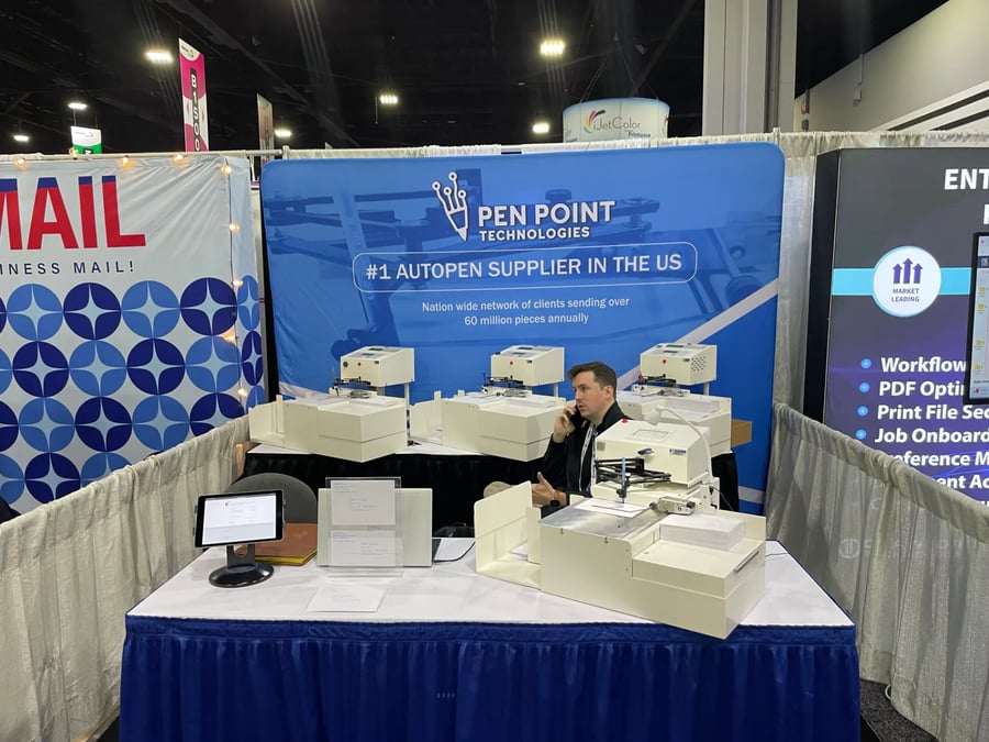 Pen Point Technologies trade-show booth with multiple UniProd handwriting machines on display